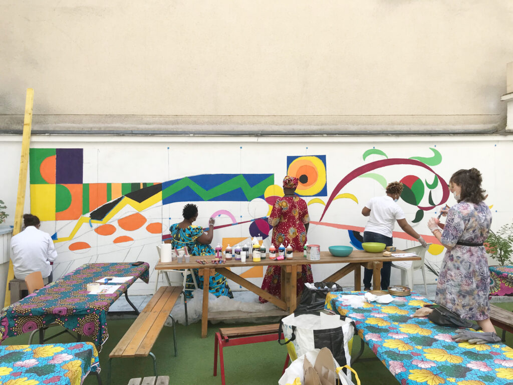 Maison Marceau, des femmes peignent une fresque extérieure, tiers-lieu relevant de l'urbanisme transitoire - Plateau Urbain