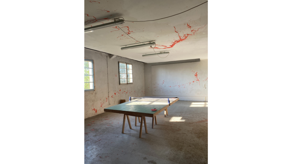 table de ping-pong dans une pièce ensoleillée, béton murs et sols