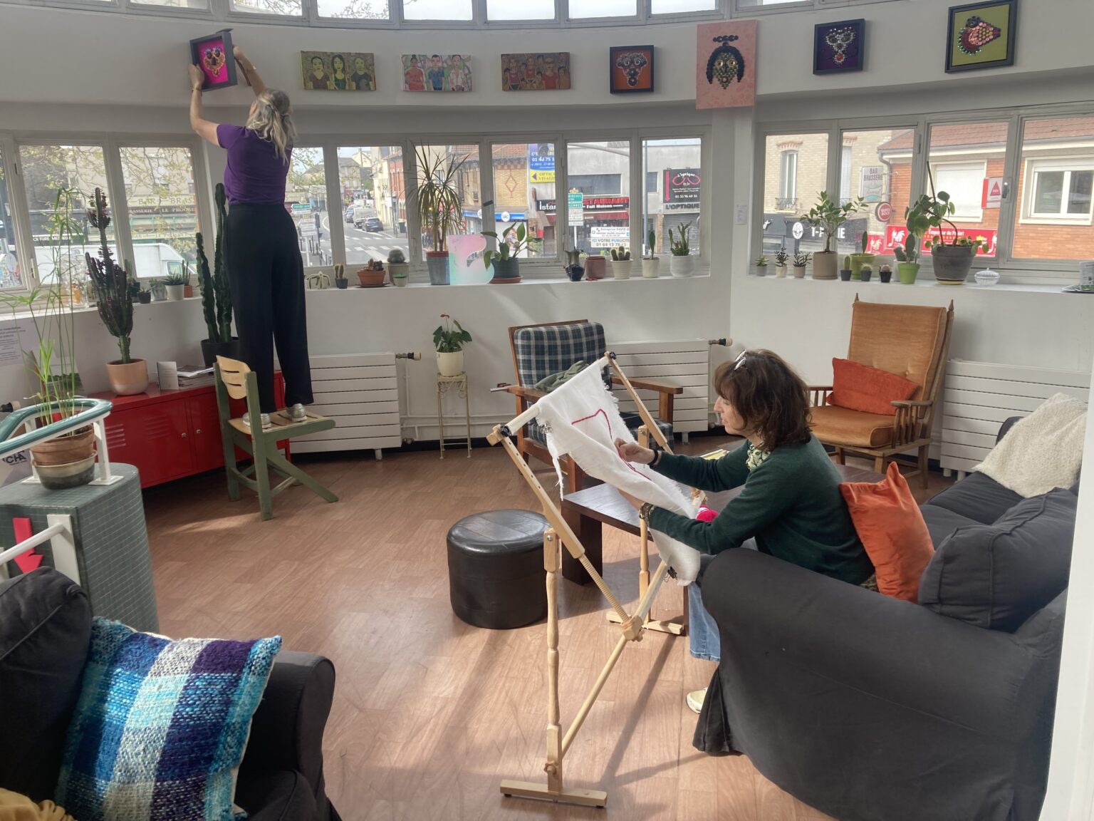 salle commune ensoleillée, peintre peignant, plantes, tableaux