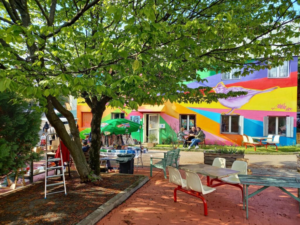 Tiers lieu de La Grange, bâtiment extérieur, façades colorées, chaises et tables pour les occupants